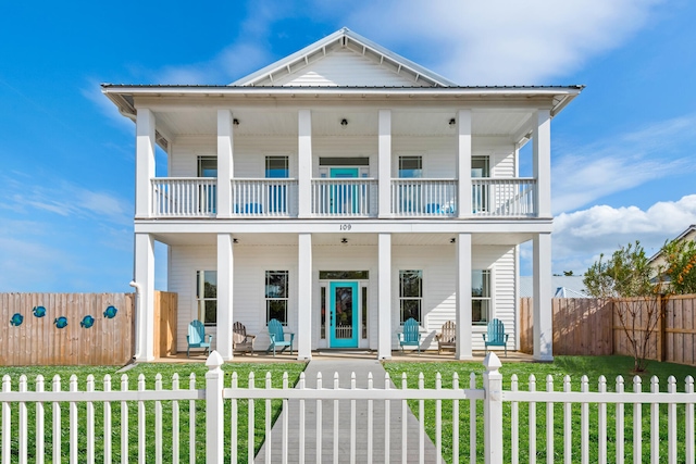 view of front of home with a balcony and a front yard