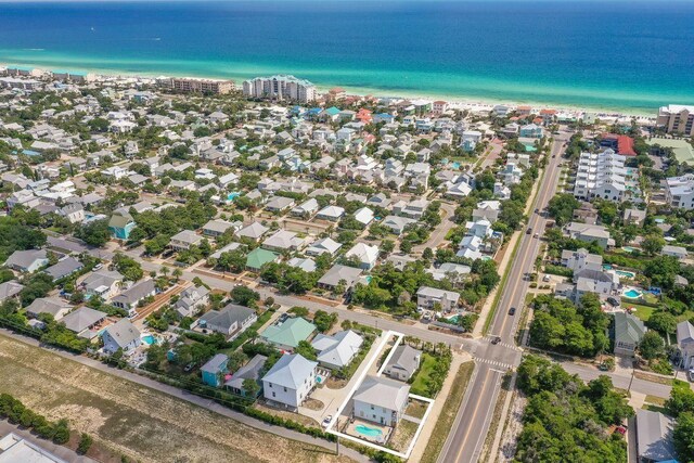 bird's eye view with a water view, a view of the beach, and a residential view