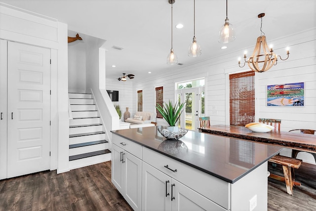 kitchen featuring dark wood-type flooring, decorative light fixtures, dark countertops, and a chandelier