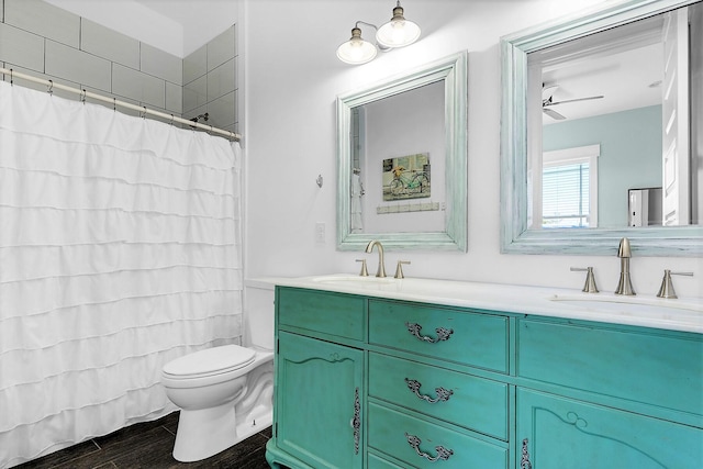full bath featuring double vanity, toilet, a sink, and wood finish floors