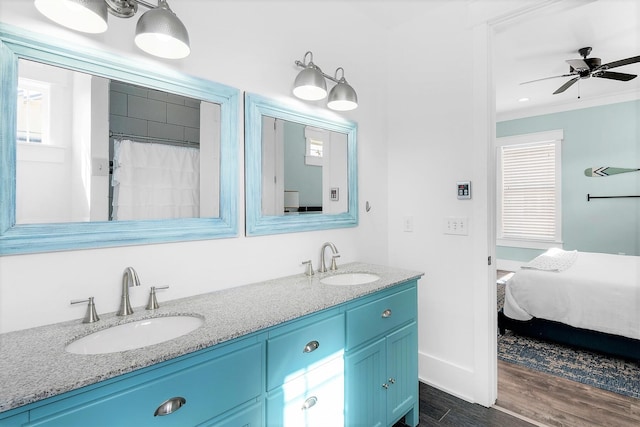 bathroom with double vanity, a sink, crown molding, and wood finished floors