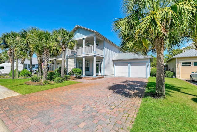 view of front of home featuring a balcony, a front yard, and covered porch