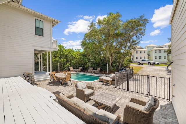 wooden terrace featuring fence, an outdoor hangout area, a fenced in pool, and a patio