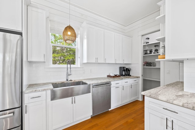 kitchen featuring white cabinets, appliances with stainless steel finishes, open shelves, and a sink