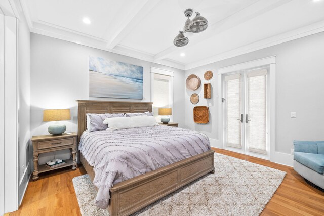 bedroom featuring light wood-type flooring, beam ceiling, crown molding, and access to exterior