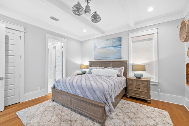 bedroom with beam ceiling, ceiling fan, crown molding, and wood-type flooring