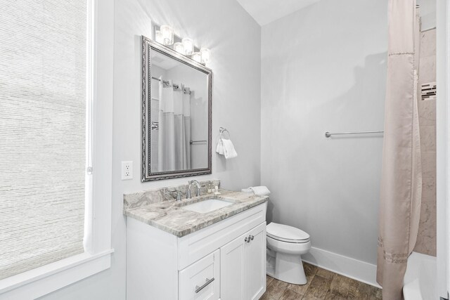 full bathroom with shower / bath combo with shower curtain, vanity, hardwood / wood-style floors, and toilet