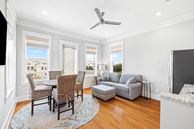 dining room with baseboards, a ceiling fan, ornamental molding, light wood-style floors, and recessed lighting