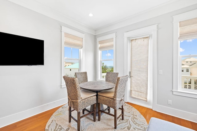 dining space featuring light hardwood / wood-style flooring and ornamental molding