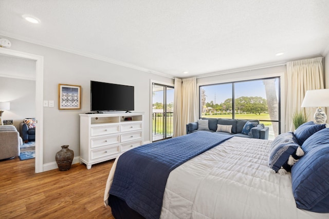 bedroom featuring hardwood / wood-style floors, ornamental molding, and access to outside