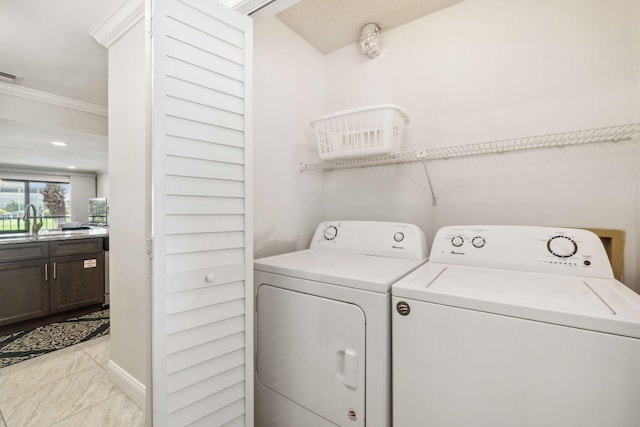 clothes washing area featuring sink, washer and dryer, light tile patterned flooring, and ornamental molding