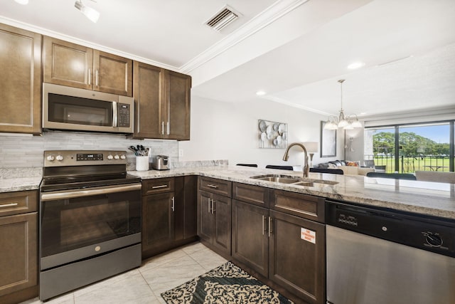 kitchen with tasteful backsplash, ornamental molding, sink, a notable chandelier, and stainless steel appliances