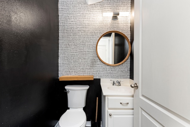 bathroom with vanity, toilet, and tile walls