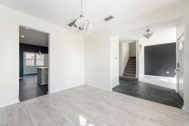 empty room featuring an inviting chandelier and dark hardwood / wood-style flooring