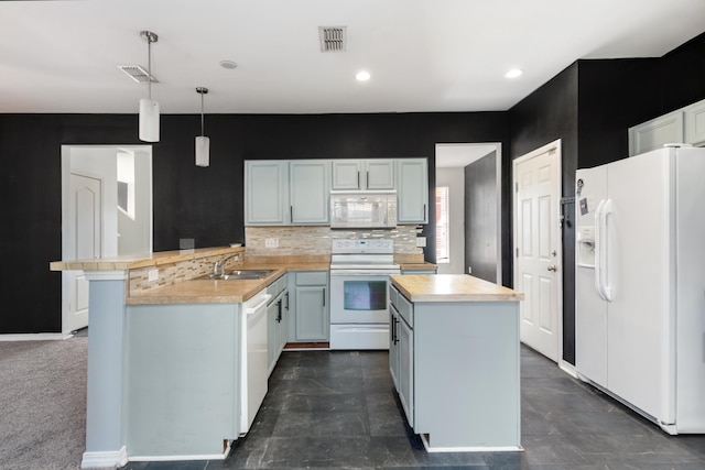 kitchen featuring white appliances, sink, kitchen peninsula, decorative light fixtures, and decorative backsplash