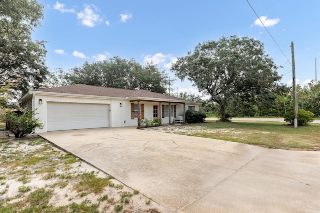 single story home with a porch, a garage, and a front yard