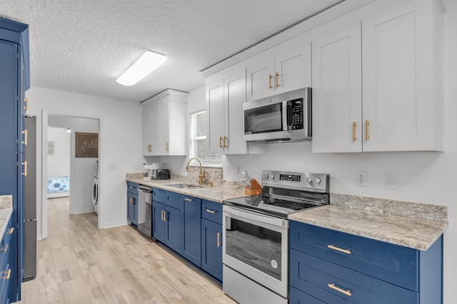 kitchen featuring blue cabinets, sink, light hardwood / wood-style flooring, stainless steel appliances, and white cabinets