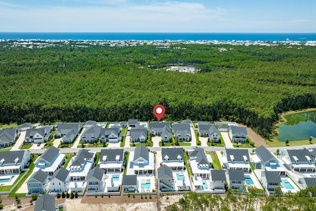 aerial view featuring a residential view, a water view, and a wooded view