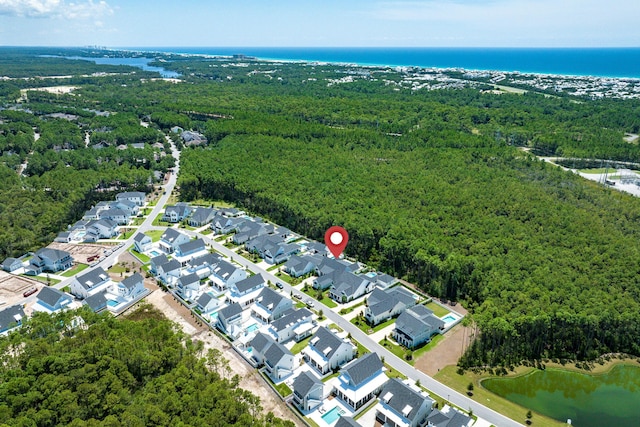 birds eye view of property featuring a water view, a forest view, and a residential view