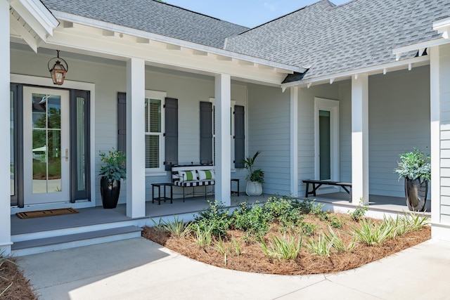 property entrance with a shingled roof and a porch