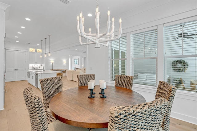 dining space with ceiling fan with notable chandelier, recessed lighting, and light wood-style floors