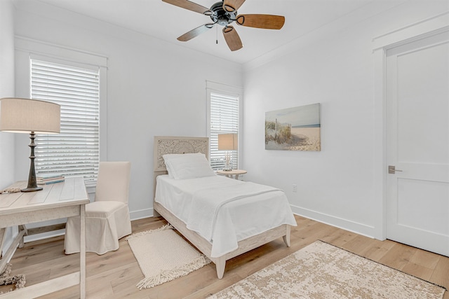 bedroom featuring light wood finished floors and baseboards