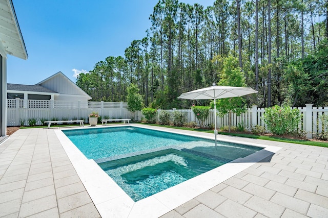 view of swimming pool featuring a patio, a fenced backyard, and a pool with connected hot tub