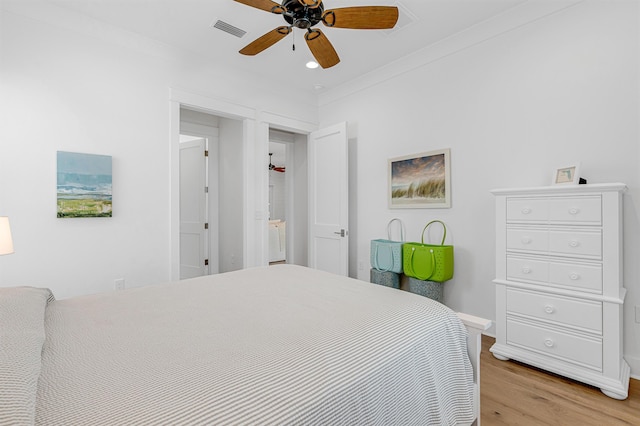 bedroom with light wood finished floors, visible vents, ornamental molding, ceiling fan, and baseboards