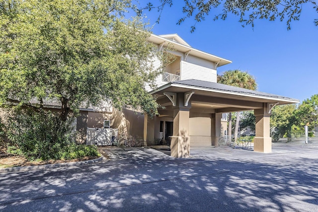 view of front of home with a balcony, aphalt driveway, and stucco siding