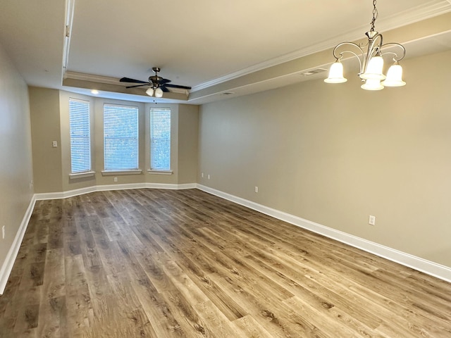 unfurnished room with baseboards, crown molding, a tray ceiling, and wood finished floors