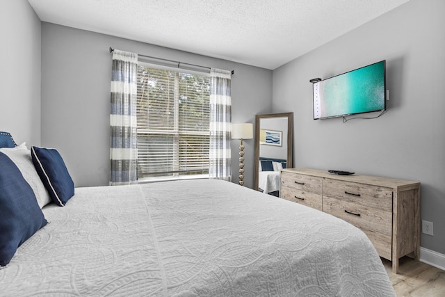 bedroom with a textured ceiling and hardwood / wood-style floors