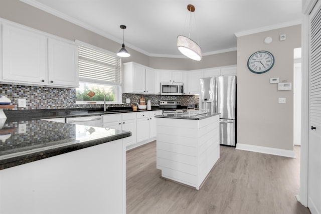 kitchen with white cabinets, a center island, hanging light fixtures, stainless steel appliances, and a sink