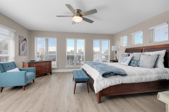 bedroom featuring light wood-style floors, baseboards, and a ceiling fan