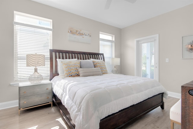 bedroom with light wood-type flooring, baseboards, and a ceiling fan