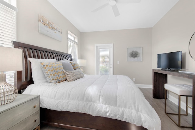 bedroom with a ceiling fan, baseboards, and wood finished floors