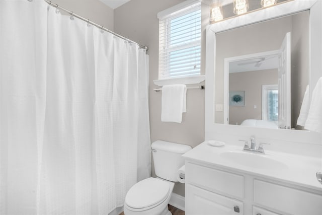 full bathroom featuring toilet, a wealth of natural light, and vanity