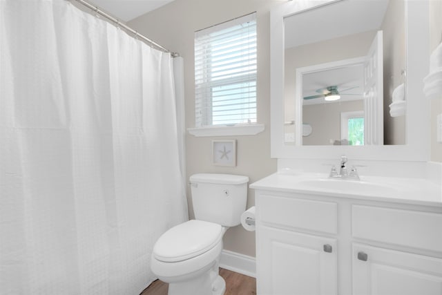 full bath with a healthy amount of sunlight, toilet, wood finished floors, and vanity