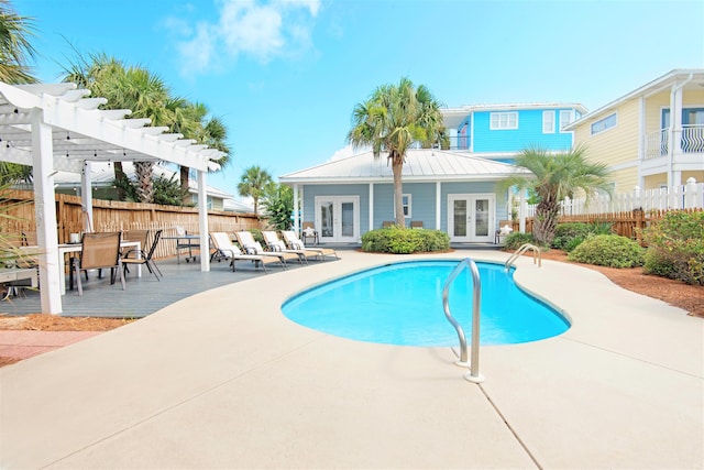 view of swimming pool featuring a patio, fence, a pergola, and french doors