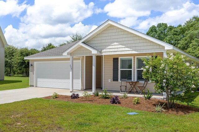 view of front of house with a garage, a front lawn, and covered porch