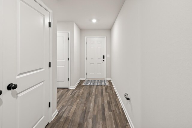 corridor with dark hardwood / wood-style flooring