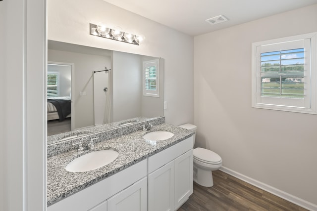 bathroom featuring dual vanity, wood-type flooring, and toilet