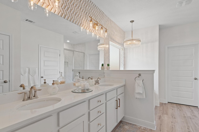 bathroom featuring an enclosed shower, vanity, and hardwood / wood-style floors