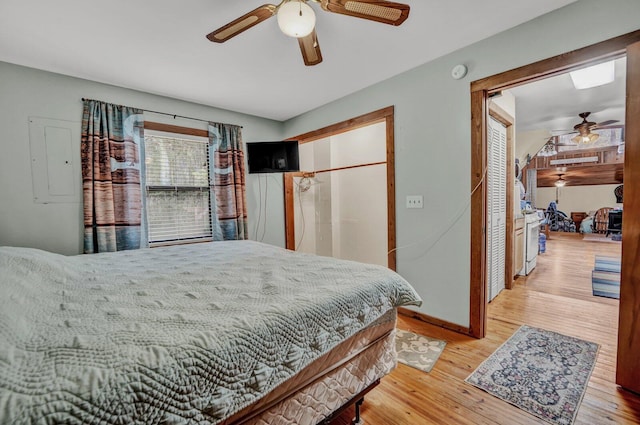 bedroom with ceiling fan, a closet, light hardwood / wood-style floors, and electric panel