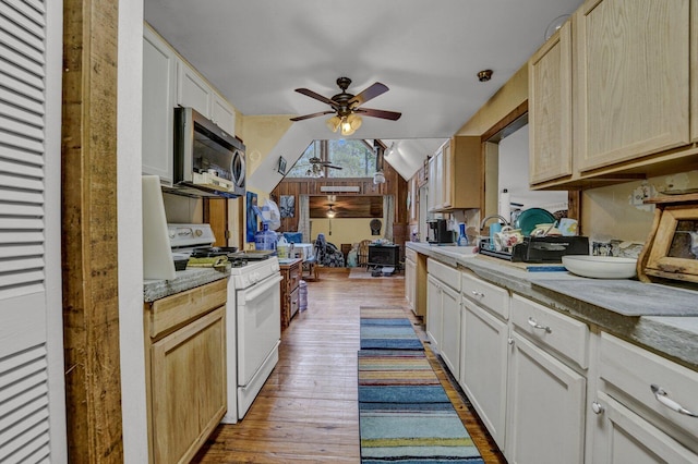 kitchen with light wood-type flooring, white range with gas stovetop, lofted ceiling, light brown cabinetry, and ceiling fan