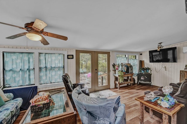 living room featuring light hardwood / wood-style flooring, ceiling fan, and french doors