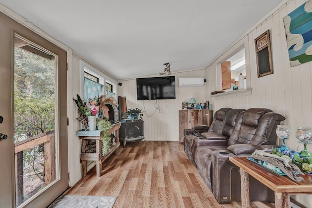 living room featuring light wood-type flooring, vaulted ceiling, and a healthy amount of sunlight