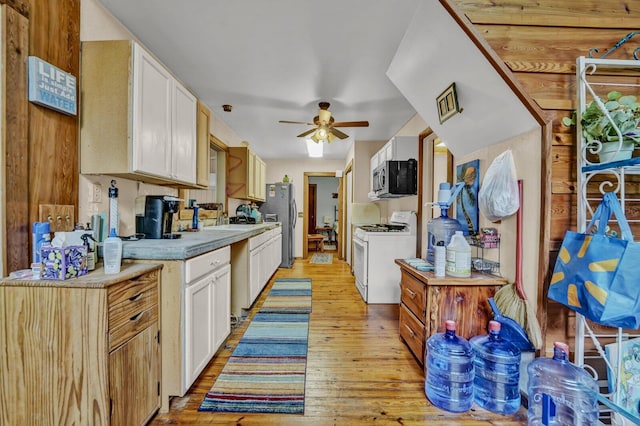 kitchen with stainless steel appliances, light hardwood / wood-style floors, white cabinetry, sink, and ceiling fan