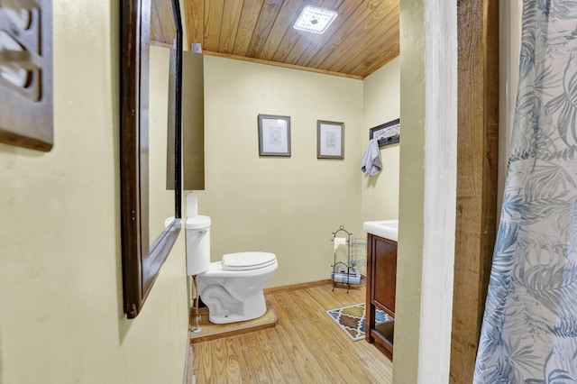 bathroom with wood-type flooring, toilet, and vanity