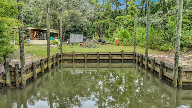 dock area with a lawn and a water view