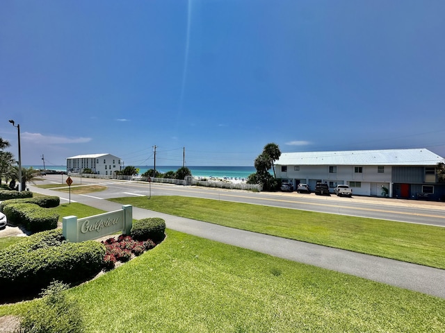 view of property's community with a water view and a yard